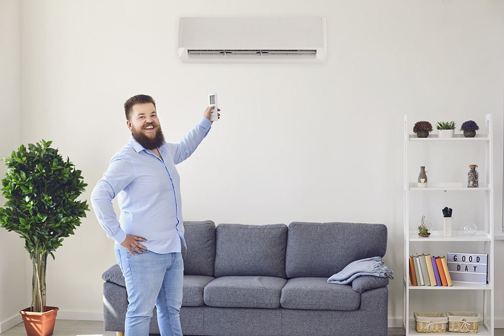 homme souriant devant une climatisation intérieure