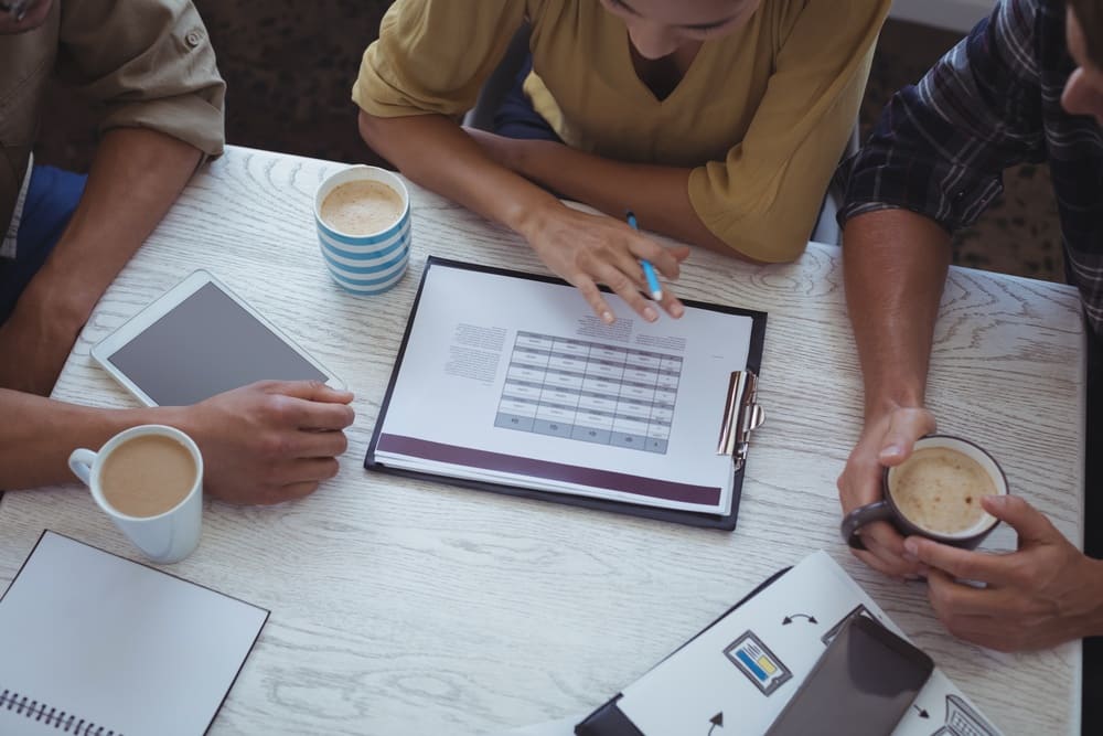 équipe vérifiant des chiffres autour d'un bureau